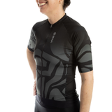 Person wearing a black and gray patterned cycling jersey on a white background