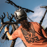 Person with a helmet on a bike against a blue sky